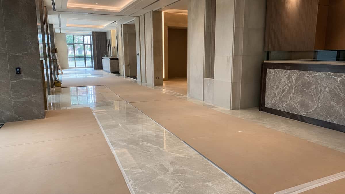 installed-stone-floor-protected-before-project-handover Installed stone floor protected before project handover in a clean commercial interior