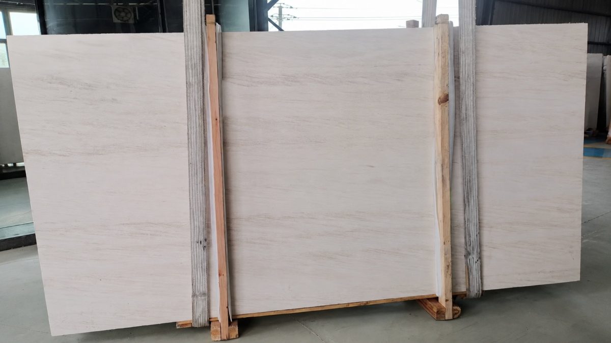 Full slabs of pale French Wood Grain Limestone on a timber-supported storage rack