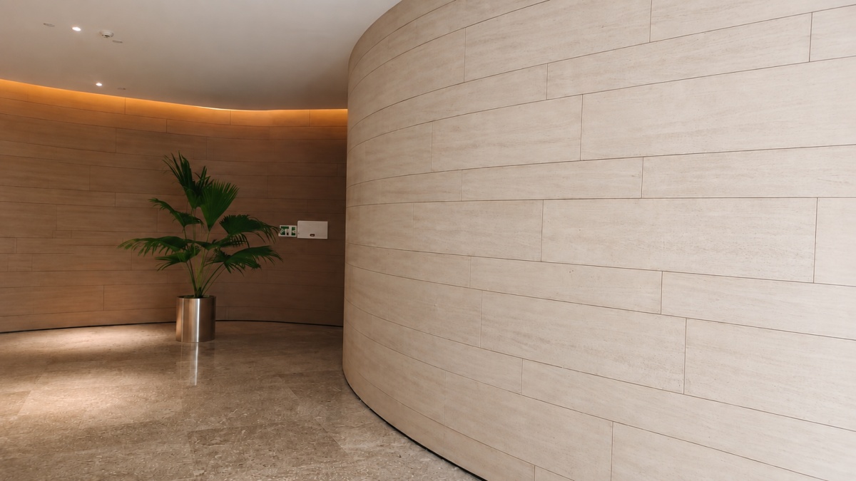 Light ivory wood grain limestone panels installed on a straight hospitality wall